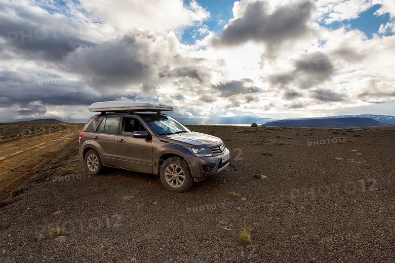 SUV, SUV with roof tent parked next to gravel road F35, Kjalvegur Kjölur, barren stony volcanic landscape, plateau, dramatic cloudy sky, Icelandic highlands, Suðurland, Sudurland, Iceland
