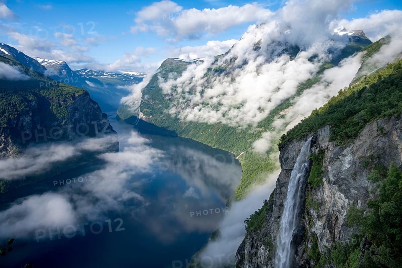 Gjerdefossen waterfall, at Ørnesvingen viewpoint, atmospheric clouds over the fjord in the morning light, at Geirangerfjord, near Geiranger, Møre og Romsdal, Norway