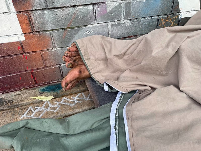 Homeless man sleeping on a bench, Yorkstrasse corner Möckernstrasse, Friedrichshain-Kreuzberg district, social issue, poverty, homelessness