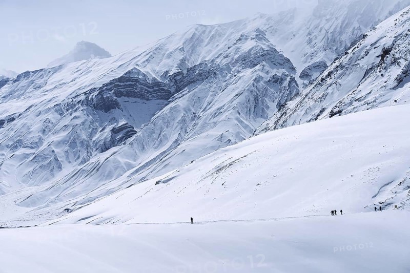 People walking through the snow, in the high mountains, Himalayas, Spitital, Kaza, Himachal Pradesh, India