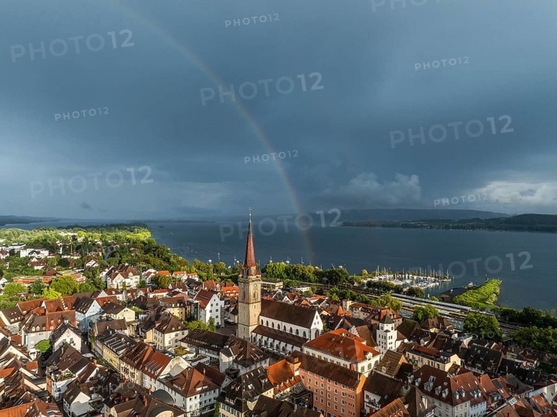 Luftbild von der Stadt Radolfzell am Bodensee mit der historischen Altstadt und dem Radolfzeller Münster nach einem Gewitterschauer von der Abendsonne angestrahlt, am Horizont ein Regenbogen, Landkreis Konstanz, Baden-Württemberg, Deutschland