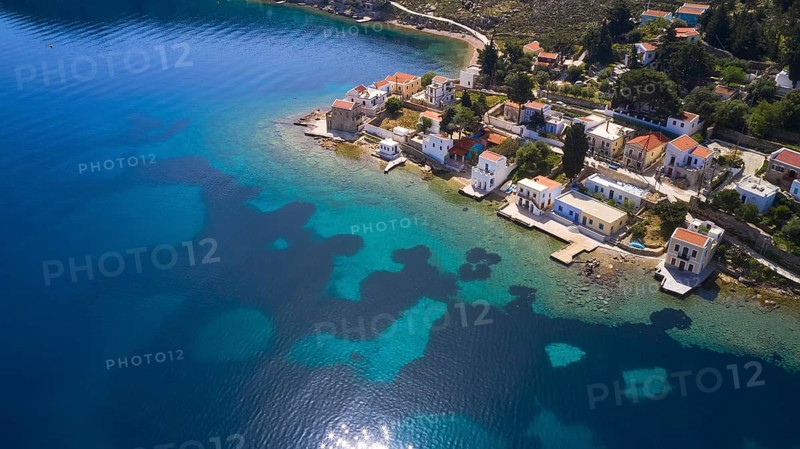 Drone shot, coastal village with white houses on the blue sea and clear coastal landscape, Bay of Emporio, Emporio, Symi, Dodecanese, Greek Islands, Greece