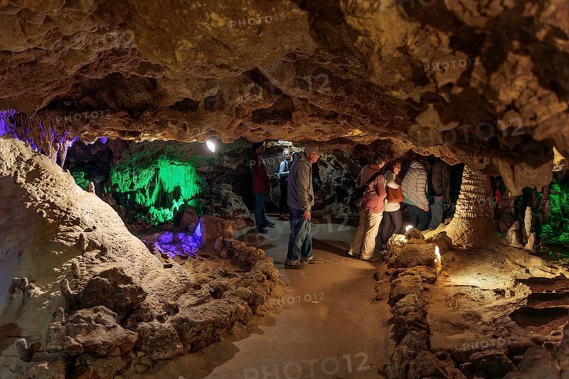 Tourists walking past limestone rock formations in a cave at Florida Caverns State Park in the Florida panhandle near Marianna