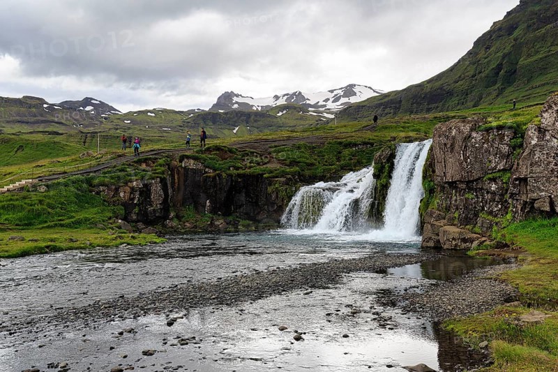 Hikers, tourists at Kirkjufellfoss waterfall, Kirkjufellsa river, Grundarfjördur, Snæfellsnes peninsula, Vesturland, Iceland