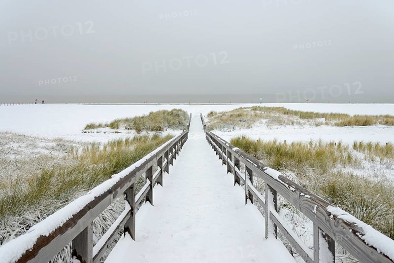 Winter day, onset of winter, wooden plank path leads through the snow-covered dune landscape to the North Sea, Norddeich, Lower Saxony, Germany