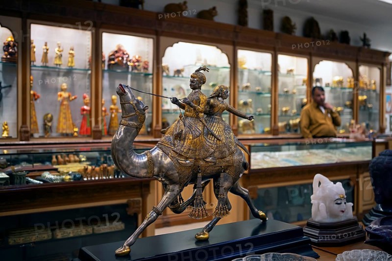 Prince and princess on a silver and gold foil camel in a shop in the old city centre, Jaipur, Rajasthan, India