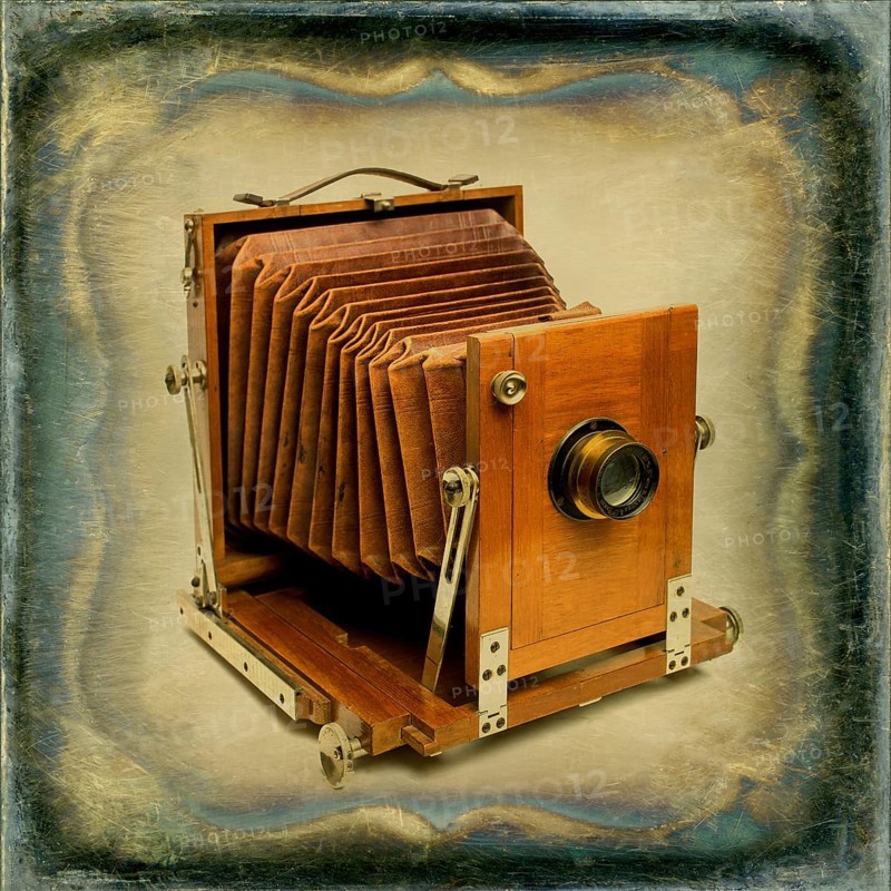Old wooden camera with bellows displayed against a textured vintage background, showcasing craftsmanship from a bygone era in photography