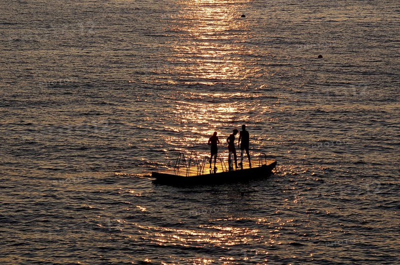 Children playing on bathing island, bathing raft, swimming island, Étretat, sea, sunset, evening mood, Normandy, Seine-Maritime, France