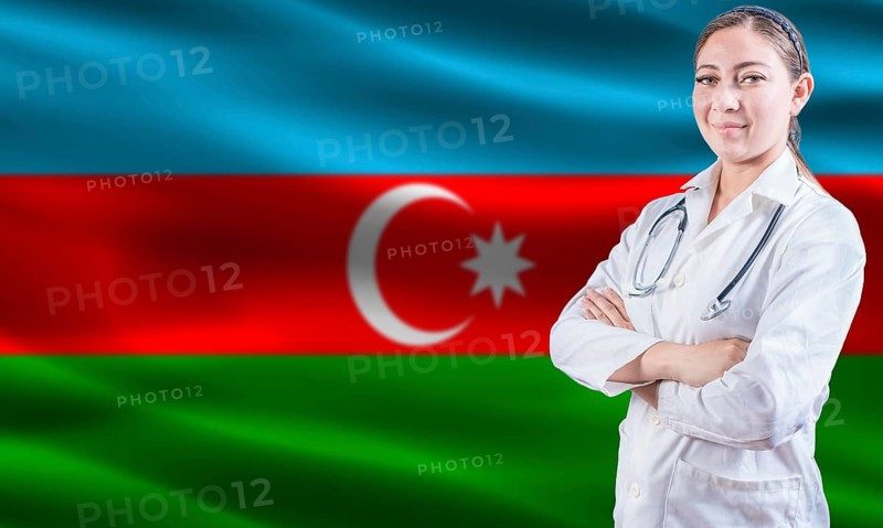 Female doctor on Azerbaijan flag. Doctor with crossed arms on Azerbaijan flag. Azerbaijan health and care concept
