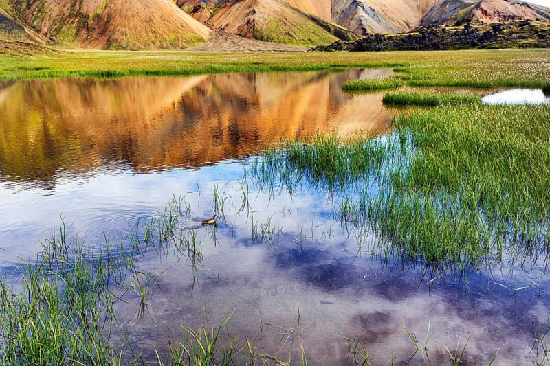 Volcanic landscape, colourful rhyolite mountains, reflection in water, Landmannalaugar, remote hiking area in Fjallabak nature reserve, Laugavegur hiking trail, Suðurland, Sudurland, Icelandic highlands, Iceland