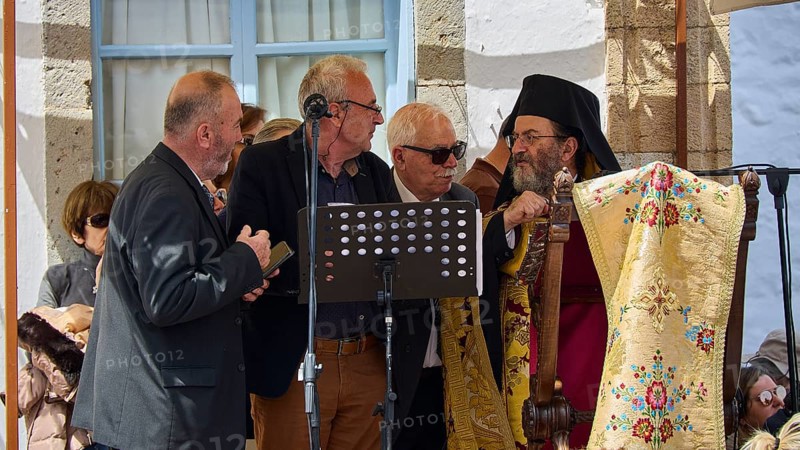Several men, including priests, discussing in front of a crowd, one holding a microphone, surrounded by traditional clothing, Orthodox ceremony, monks of St John's Monastery, ceremonial washing of feet, procession, Maundy Thursday, Megali Pempti, Chora, Patmos, Dodecanese, Greek Islands, Greece