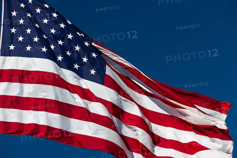 American flag waving in the wind against deep blue sky