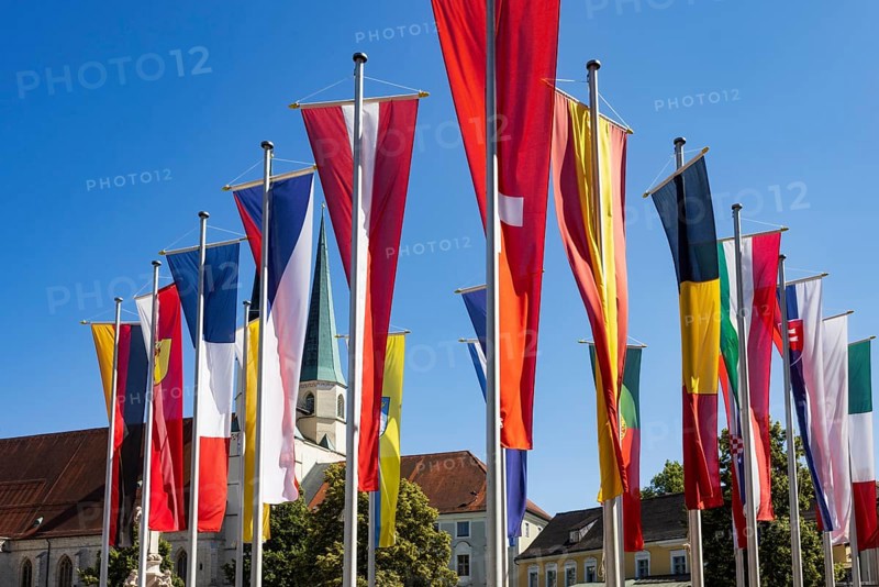 National flags at Kapellplatz with the collegiate parish church of St Philip and St James, place of pilgrimage, Altötting, Upper Bavaria, Bavaria, Germany