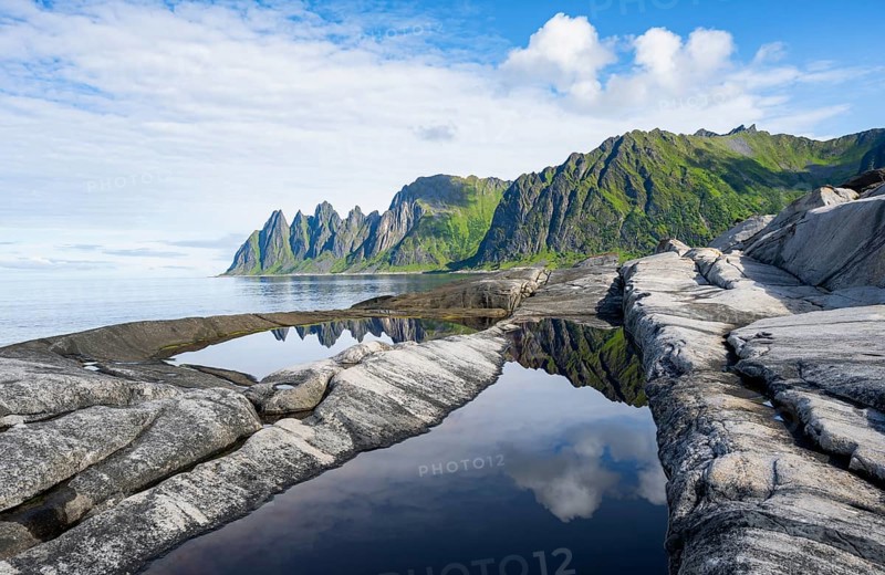 Reflection in a tidal pool, rocky coast of Tungeneset, Devil's Teeth, Okshornan, Ersfjorden, Senja Island, Troms, Norway