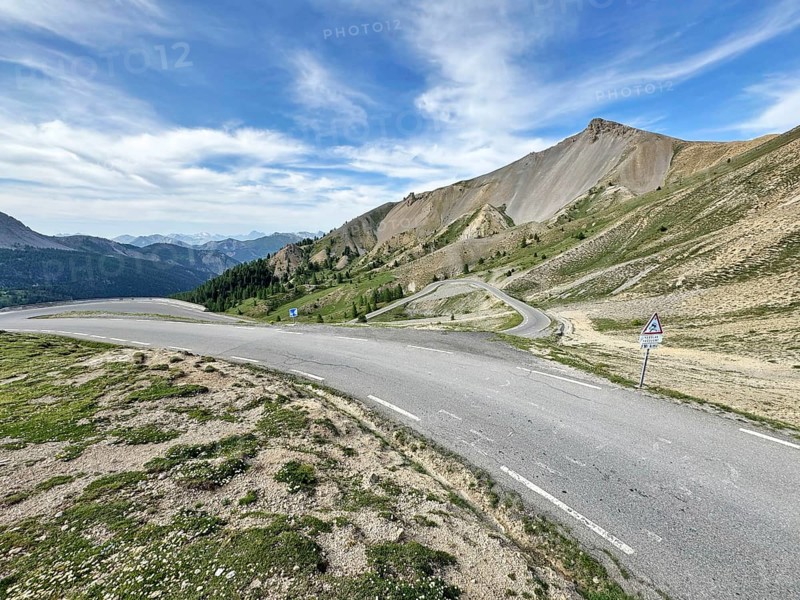 Northern ascent mountain road Alpine road with serpentines above tree line shortly in front of the top of the Col d Izoard Alpine pass, Cervières, Alpes-de-Haute-Provence, France