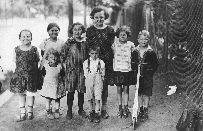 Boys and girls on the pavement, 1920s, group of children posing laughing on a rural road, historical photo