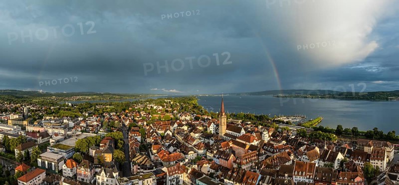 Luftbild, Panorama von der Stadt Radolfzell am Bodensee mit der historischen Altstadt und dem Radolfzeller Münster nach einem Gewitterschauer von der Abendsonne angestrahlt, am Horizont ein Regenbogen, Landkreis Konstanz, Baden-Württemberg, Deutschland