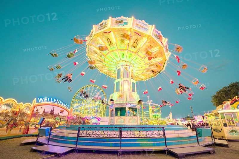 A brightly lit chain carousel turns at a daytime fair, Chain carousel, Spring festival, Cannstatter Wellenflug, Illuminated, Cannstatter Wasen, Bad Cannstatt, Stuttgart, Baden-Württemberg, Germany