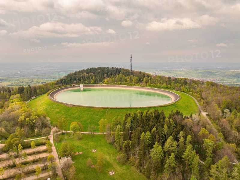 Upper reservoir Reservoir on a wooded hill with observation tower and green meadows, Glems reservoir, Swabian Alb, Germany
