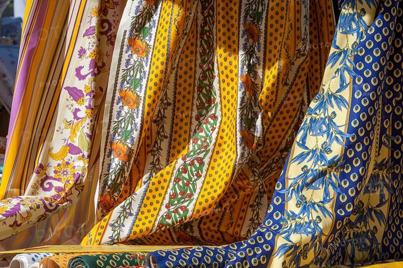 Various decorative fabrics with floral patterns in yellow and blue, typical of Provence, France