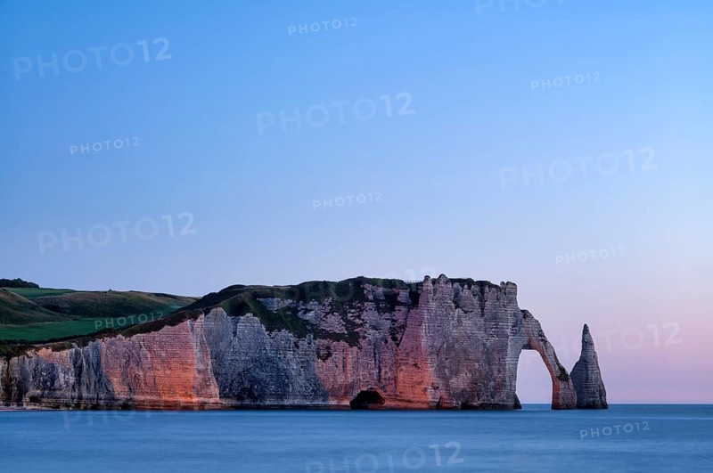 Rock arch Falaise or Porte d'Aval and rock needle Aiguille, illuminated, illuminated, Étretat, sea, steep coast, cliffs, chalk cliffs, alabaster coast, La Côte d'Albâtre, sunset, evening mood, atmospheric, Normandy, Seine-Maritime, France