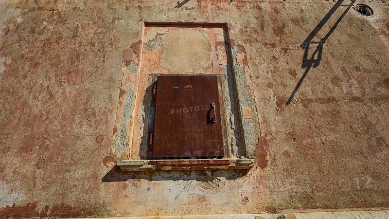 Lost Place, Locked rusty door in a weathered wall under summer light, Radio Station, WW2, Agios Nikolaos Radio, Agia Marina, Leros, Dodecanese, Greek Islands, Greece
