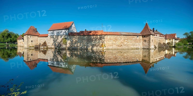The town wall with defence towers and half-timbered house is reflected in the lake pond, Seeweihermauer, Weißenburg in Bayern, Mittelfranken, Franconia, Bavaria, Germany