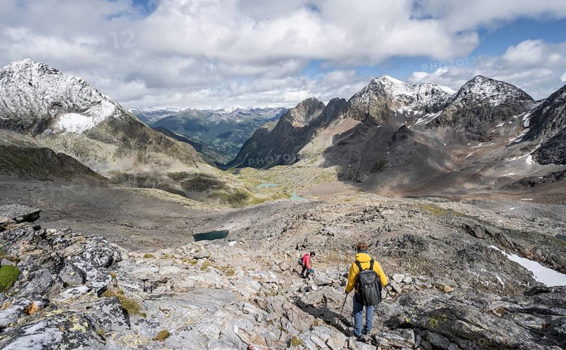 Two mountaineers in a rocky mountain landscape, descending from the summit of Keeskopf, behind them summit of Petzeck, Hoher Perschitzkopf and Kruckelkopf, Schober Group, Hohe Tauern National Park, Carinthia, Austria