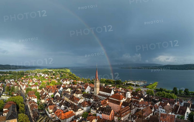 Luftbild von der Stadt Radolfzell am Bodensee mit der historischen Altstadt und dem Radolfzeller Münster nach einem Gewitterschauer von der Abendsonne angestrahlt, am Horizont ein Regenbogen, Landkreis Konstanz, Baden-Württemberg, Deutschland