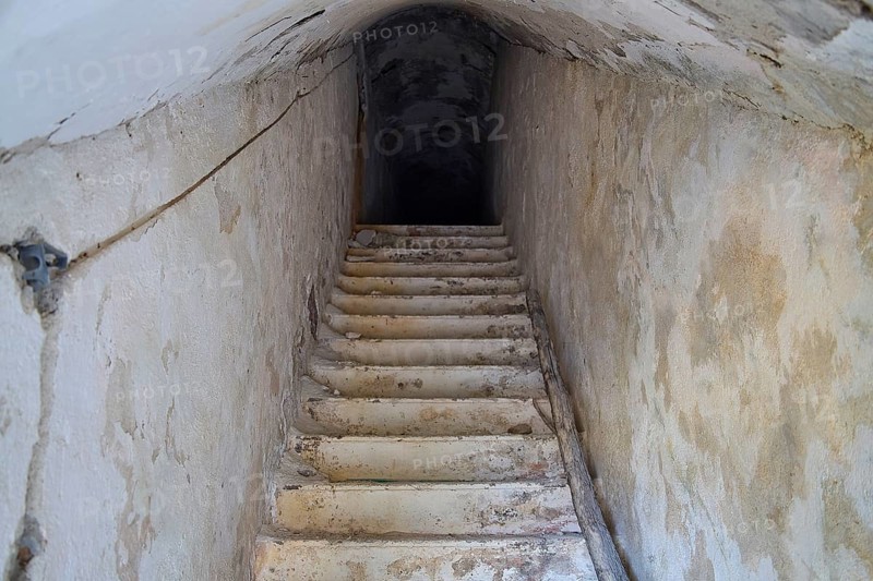 An old, narrow staircase leading deep into the darkness of an underground passage, Lost Place, Lago anti-aircraft battery, Bunker, Apitiki Mountain, Leros, Dodecanese, Greek Islands, Greece