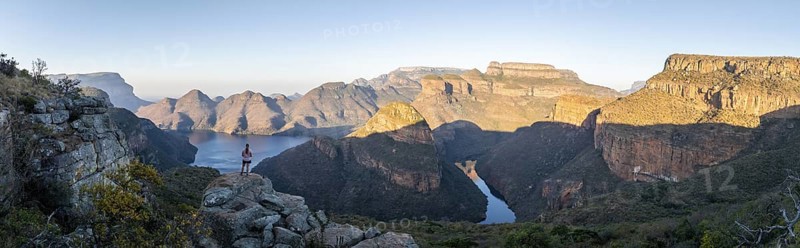 Hiker enjoying panorama, sunset at Blyde River Canyon with Three Rondawels peak, view of canyon with Blyde River and table mountains in the evening light, canyon landscape, Panorama Route, Mpumalanga, South Africa