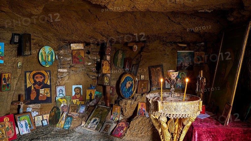 Icon-decorated cave altar with glowing candles, surrounded by religious artworks and paintings, chapel, Agios Nikolaos, rock chapel, Oasis Beach, East Coast Rhodes, Rhodes, Dodecanese, Greek Islands, Greece