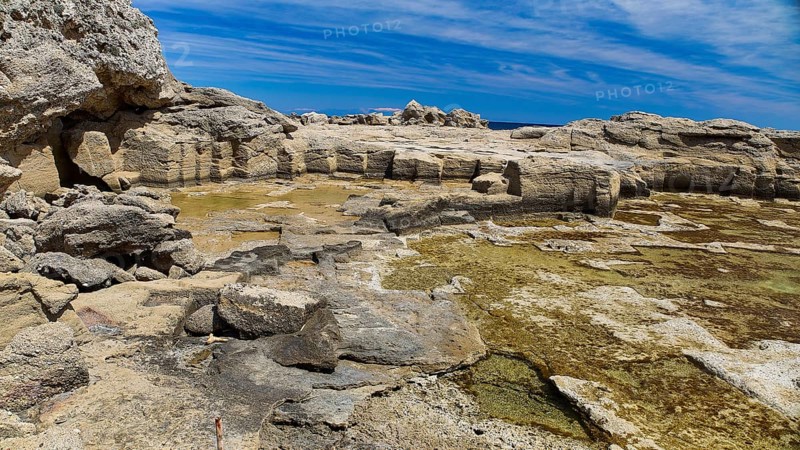 Rocks and seaweed on the coast under a clear sky, Oasis Beach, East Coast Rhodes, Rhodes, Dodecanese, Greek Islands, Greece