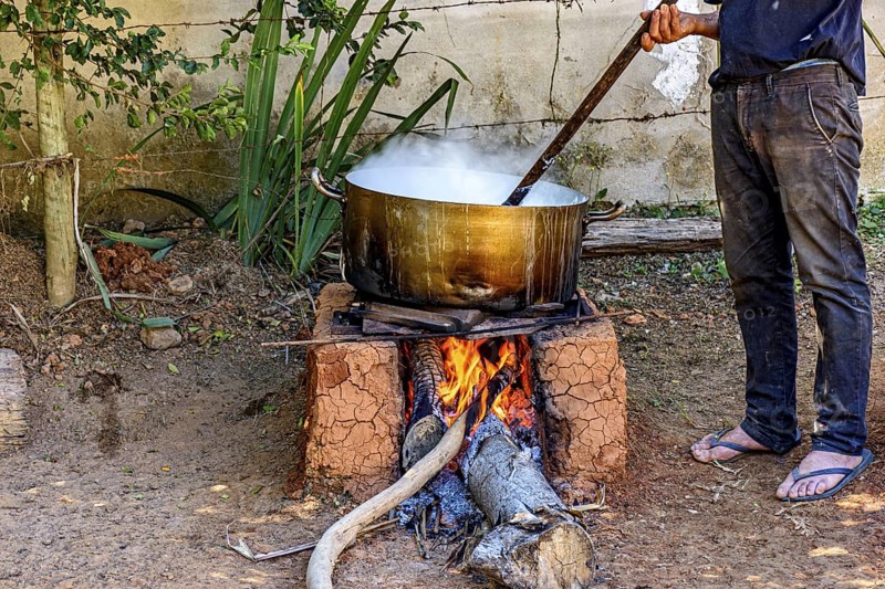 Person preparing a meal in the backyard on a wood-burning stove typically used in Minas Gerais, Brazil, Minas Gerais, Brazil
