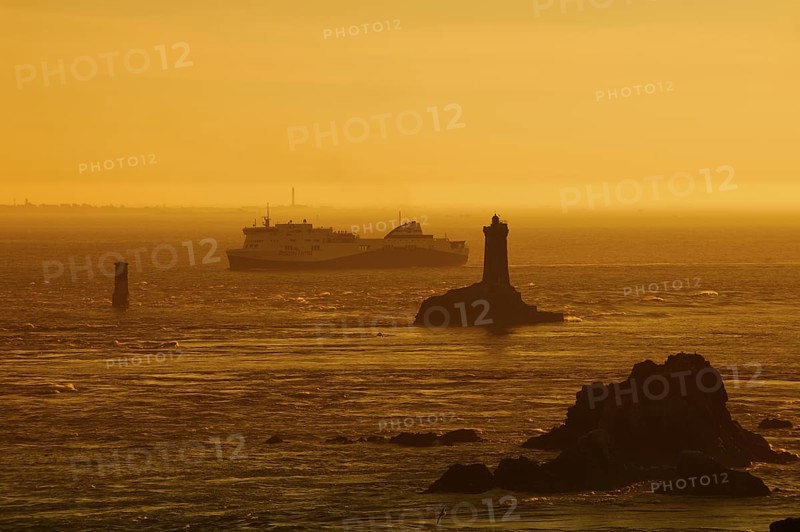 Phare de la Vieille lighthouse and ferryboat at sunset, Pointe du Raz, Cap Sizun, Finistere department, Brittany, France
