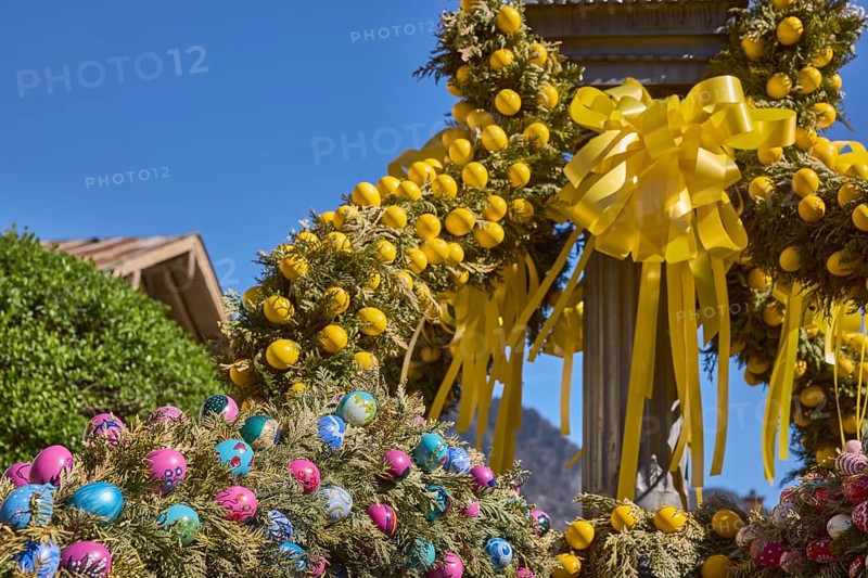 Easter fountain, Easter decoration, blown out coloured Easter eggs, trees, historical buildings, blue sky, cloudless, Florianiplatz, Bad Reichenhall, district Berchtesgadener Land, Bavaria, Germany
