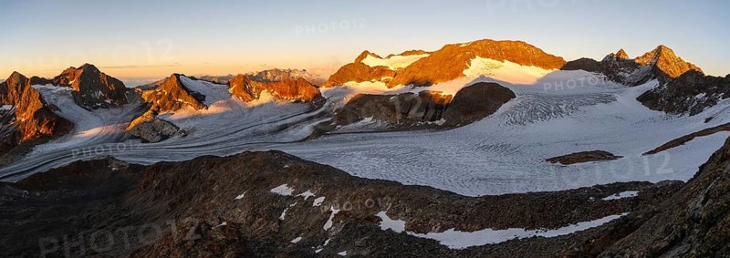 Picturesque high mountain landscape at sunrise with alpenglow, blue glacial lakes, glaciers and rocky mountain peaks in the morning light, view at Becher of mountain peaks Königshofspitz and Sonklarspitze and Schwarzwandspitz with glacier Übeltalferner, Stubai Alps, South Tyrol, Italy