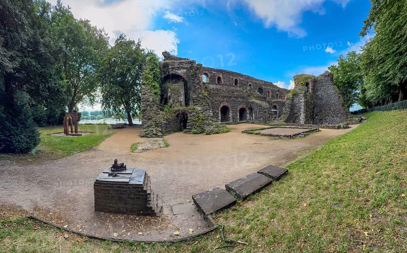 Panoramic photo of the ruins of the imperial palace of Emperor Frederick I Barbarossa, built in the Middle Ages around 1184 on the left in the background of today's banks of the Rhine, in the foreground small model of the original fortress building, Kaiserswerth, Düsseldorf, North Rhine-Westphalia, Germany
