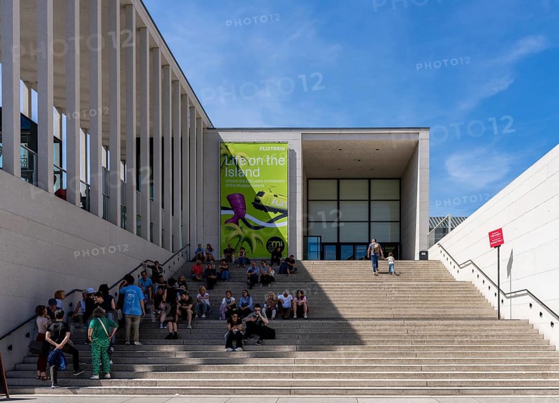 Tourists sitting on the stairs to the James Simon Gallery, Berlin, Germany