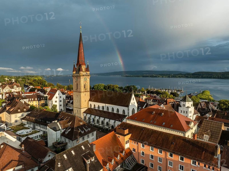 Luftbild von der Stadt Radolfzell am Bodensee mit der historischen Altstadt und dem Radolfzeller Münster nach einem Gewitterschauer von der Abendsonne angestrahlt, am Horizont ein Regenbogen, Landkreis Konstanz, Baden-Württemberg, Deutschland