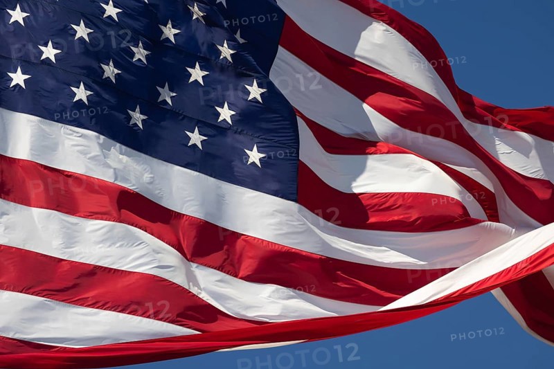 American flag waving in the wind against deep blue sky