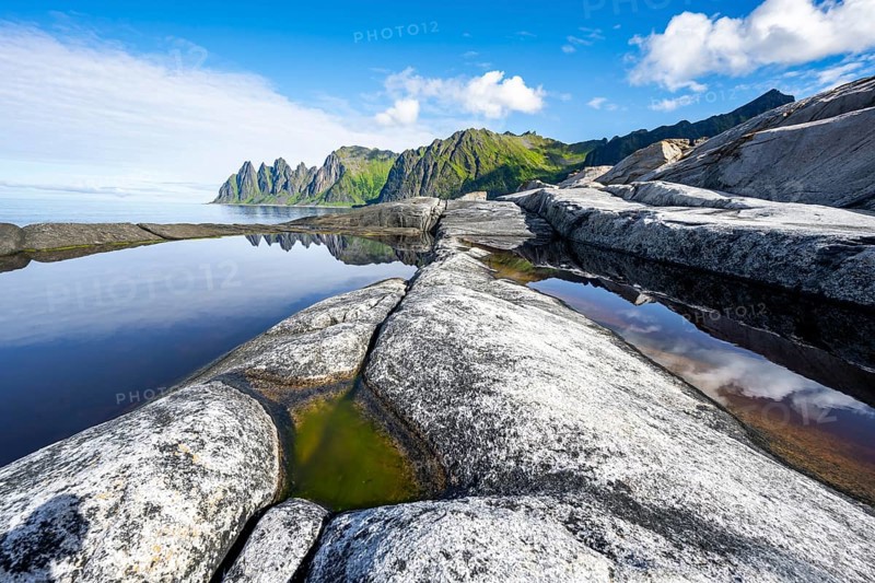 Reflection in a tidal pool, rocky coast of Tungeneset, Devil's Teeth, Okshornan, Ersfjorden, Senja Island, Troms, Norway