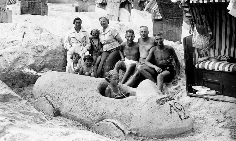 Sand car beach chair family, 1930s, family on the beach posing around a large sand car, relaxed and cheerful, historical photo