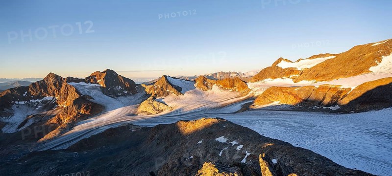 Picturesque high mountain landscape at sunrise with alpenglow, glacier and rocky mountain peaks in the morning light, view at Becher of mountain peaks Königshofspitz and Sonklarspitze and Schwarzwandspitz with glacier Übeltalferner, Stubai Alps, South Tyrol, Italy