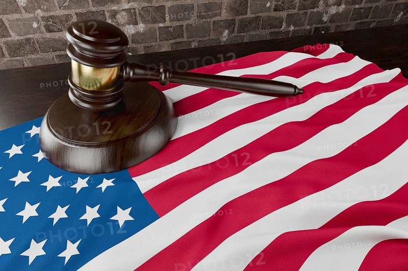 American flag and wooden gavel resting on desk