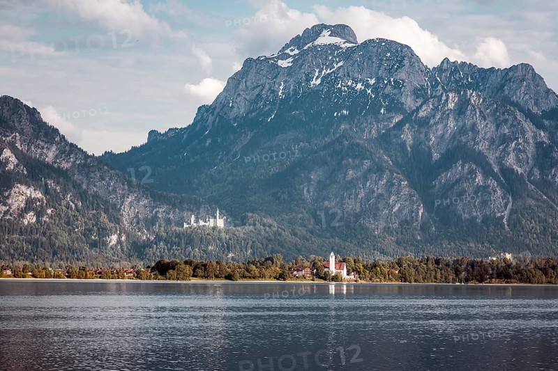 A lake against an impressive mountain backdrop with Neuschwanstein Castle in the background, Schwangau, Bavaria