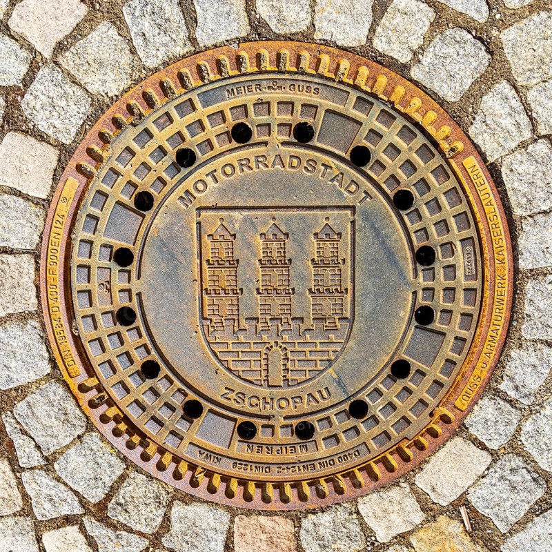 Manhole cover with the coat of arms of the motorbike town of Zschopau, Erzgebirge, Saxony, Germany