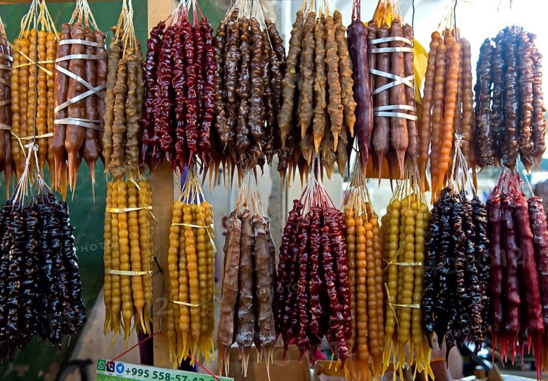 Traditional Georgian sweets Churchkhela made from walnuts and thickened grape juice, market stall in Kutaisi, Georgia