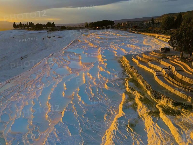 Landscape with terraces and water that glows orange and blue in the sunset light, aerial view, sinter terraces, lime sinter terraces, travertine terraces, Pamukkale, Denizli, UNESCO World Heritage Site, Anatolia, Turkey