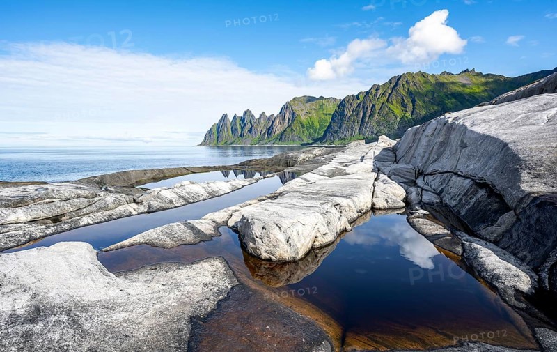 Reflection in a tidal pool, rocky coast of Tungeneset, Devil's Teeth, Okshornan, Ersfjorden, Senja Island, Troms, Norway